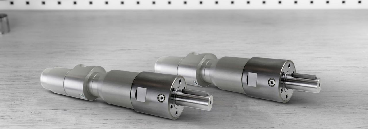 Twee compacte Deprag turbinemotoren in roestvrij staal horizontaal neergelegd op een metalen ondergrond, met lagers en onderdelen zichtbaar op de achtergrond.