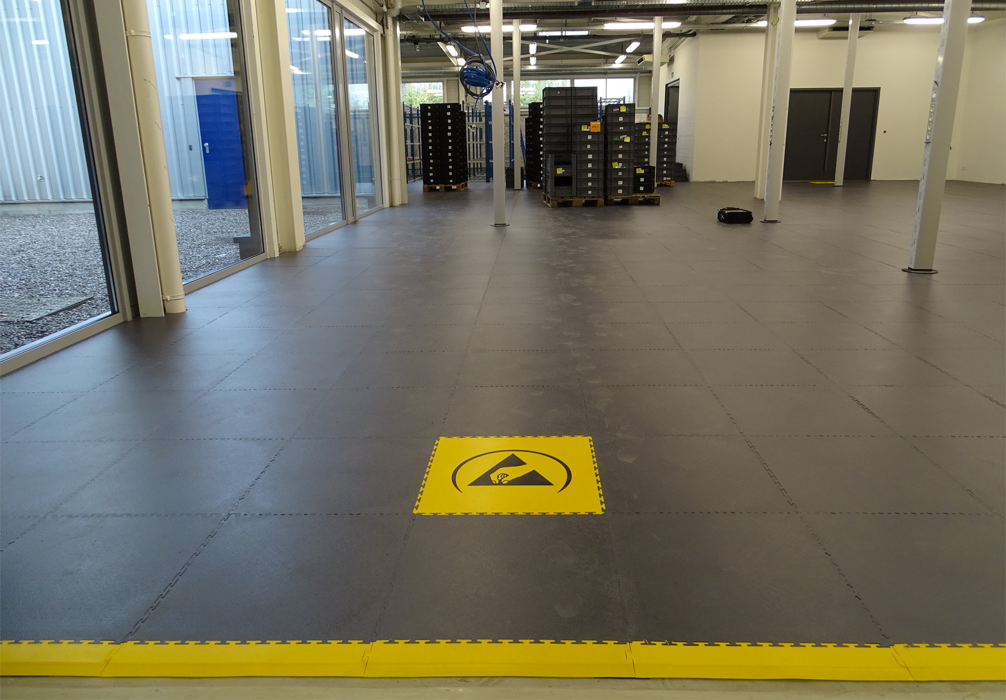 ESD-vloer met EPA-pictogram en gele vloermarkering in magazijn