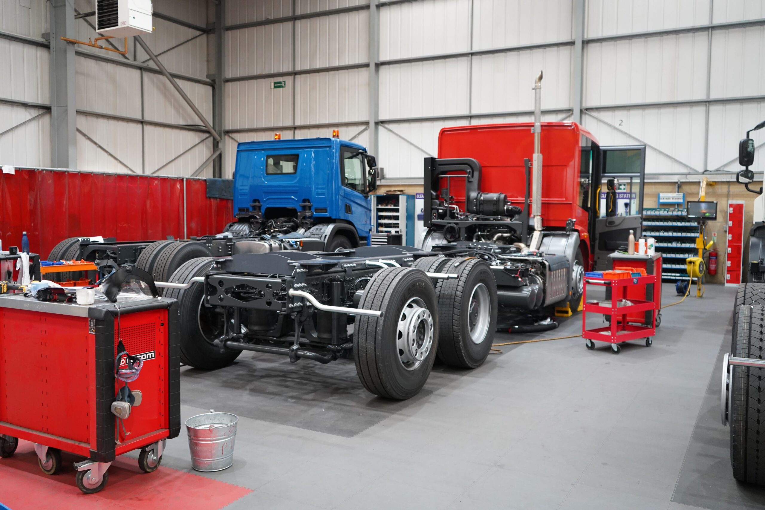 Automotive werkplaats met grijze heavy duty klikvloer en vrachtwagens in onderhoud