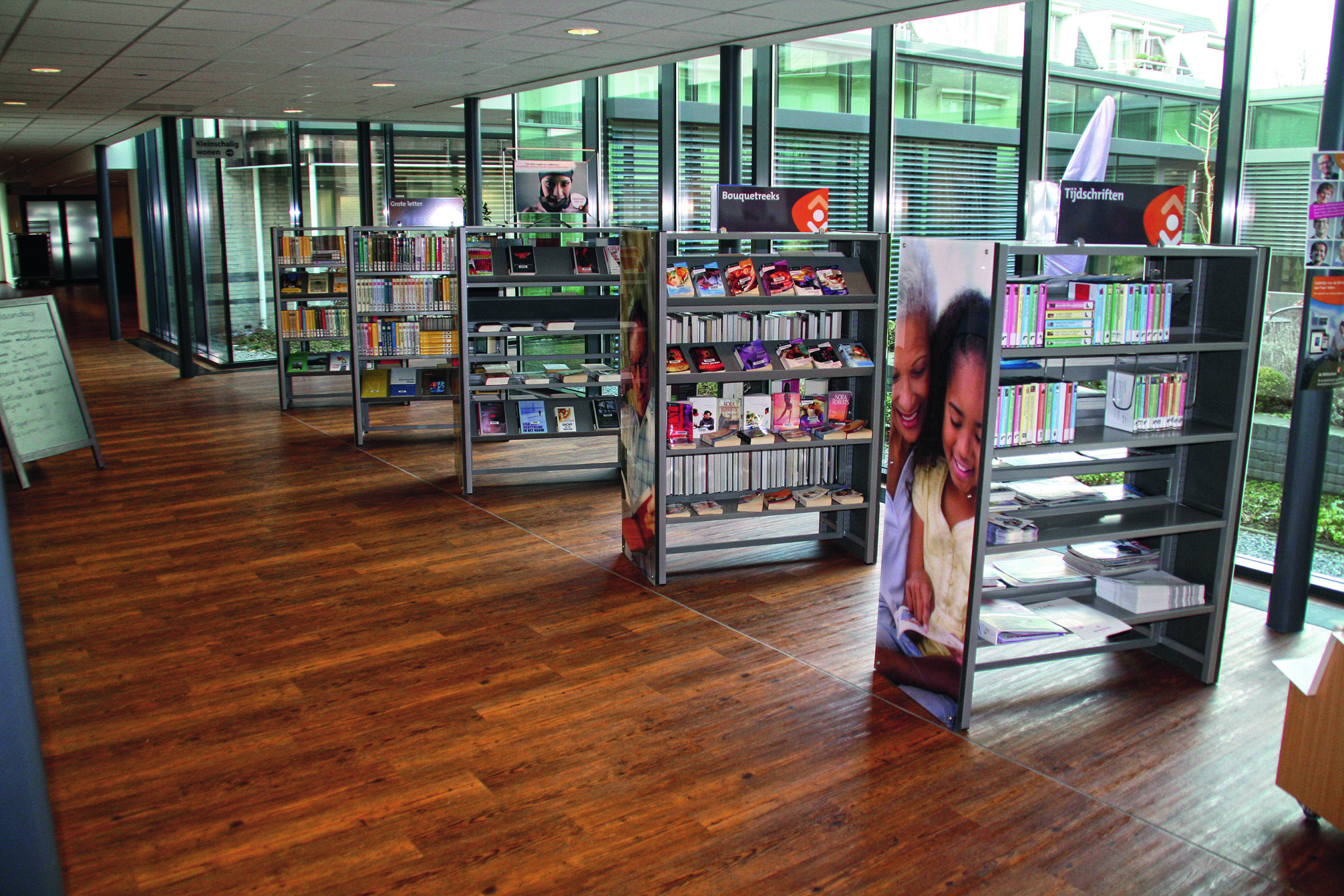 Bibliotheek met donkere decoratieve vloer in houtmotief in een bibliotheek met boekenrekken.