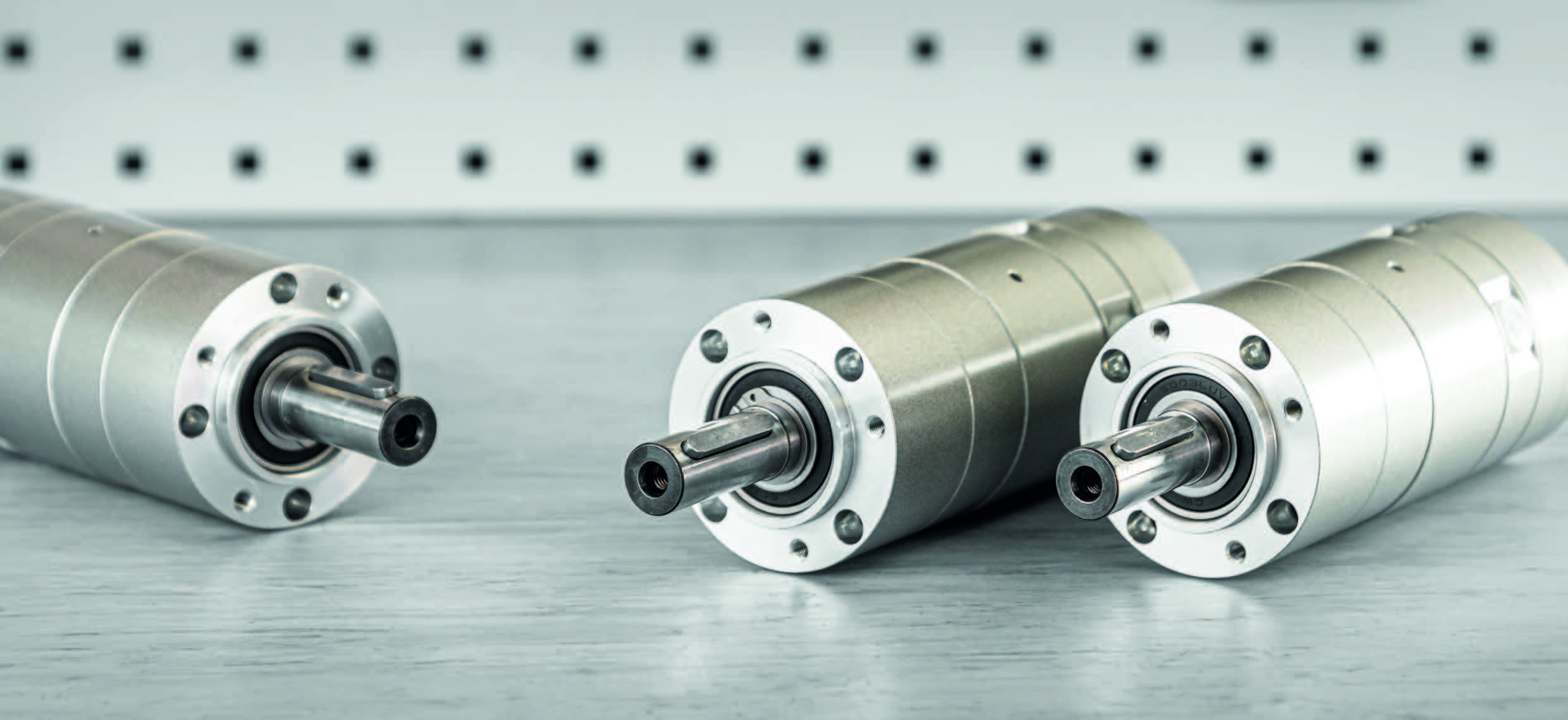 Drie zilverkleurige DEPRAG Basic Line luchtmotoren in verschillende formaten op een metalen ondergrond