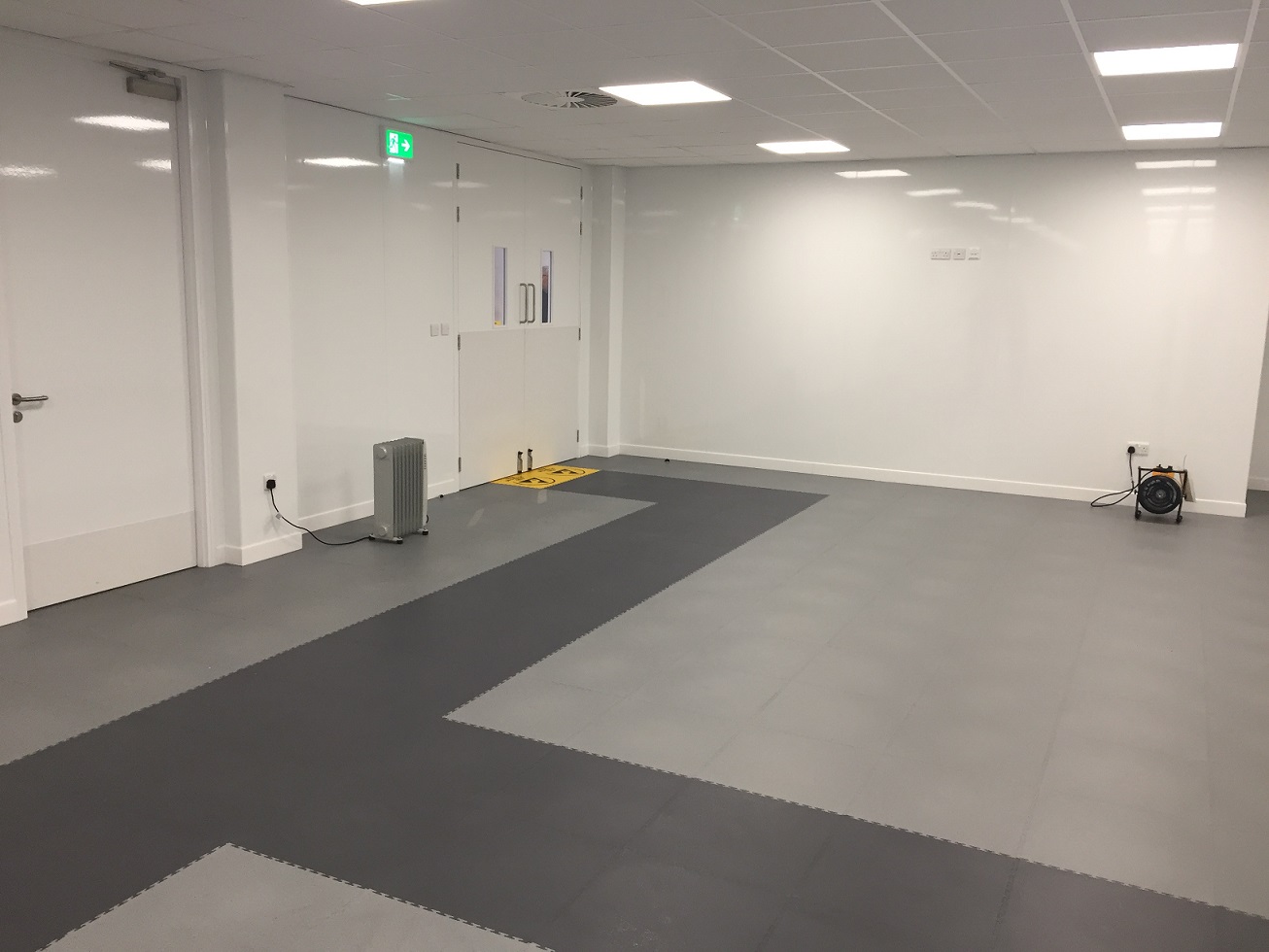 Lichte werkruimtes met grijze klikvloer in twee tinten en gele ESD-markering