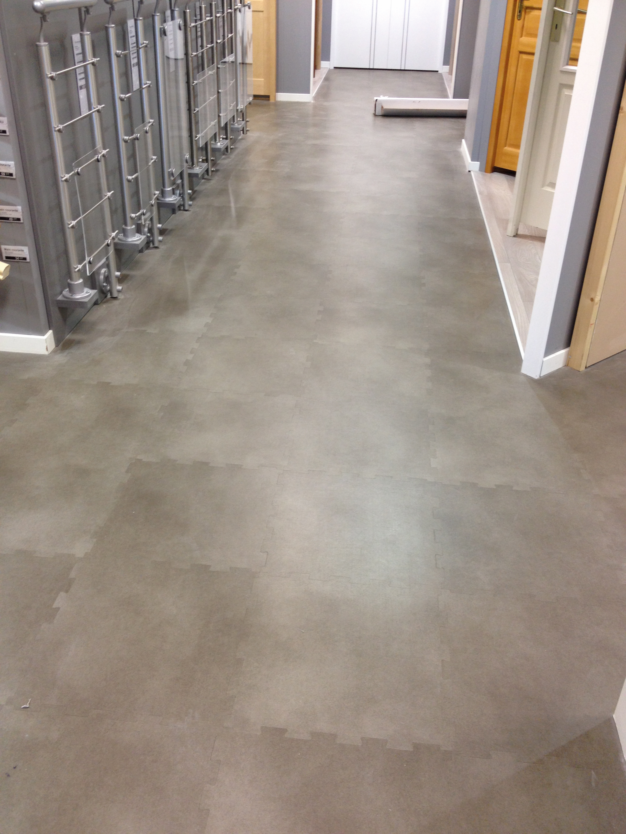 Showroom met grijze commerciële vinyl vloer in steeneffect en saniteirdisplay