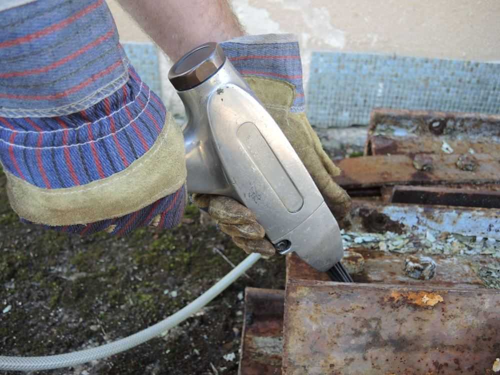 Pneumatische naaldbikhamer met lichte behuizing in gebruik bij het verwijderen van roest — AWP