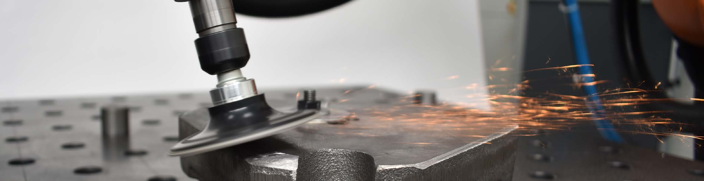Deprag Grinding System DGS slijpspindel gemonteerd op robotarm die vonken produceert tijdens het slijpen van een metalen werkstuk — AWP