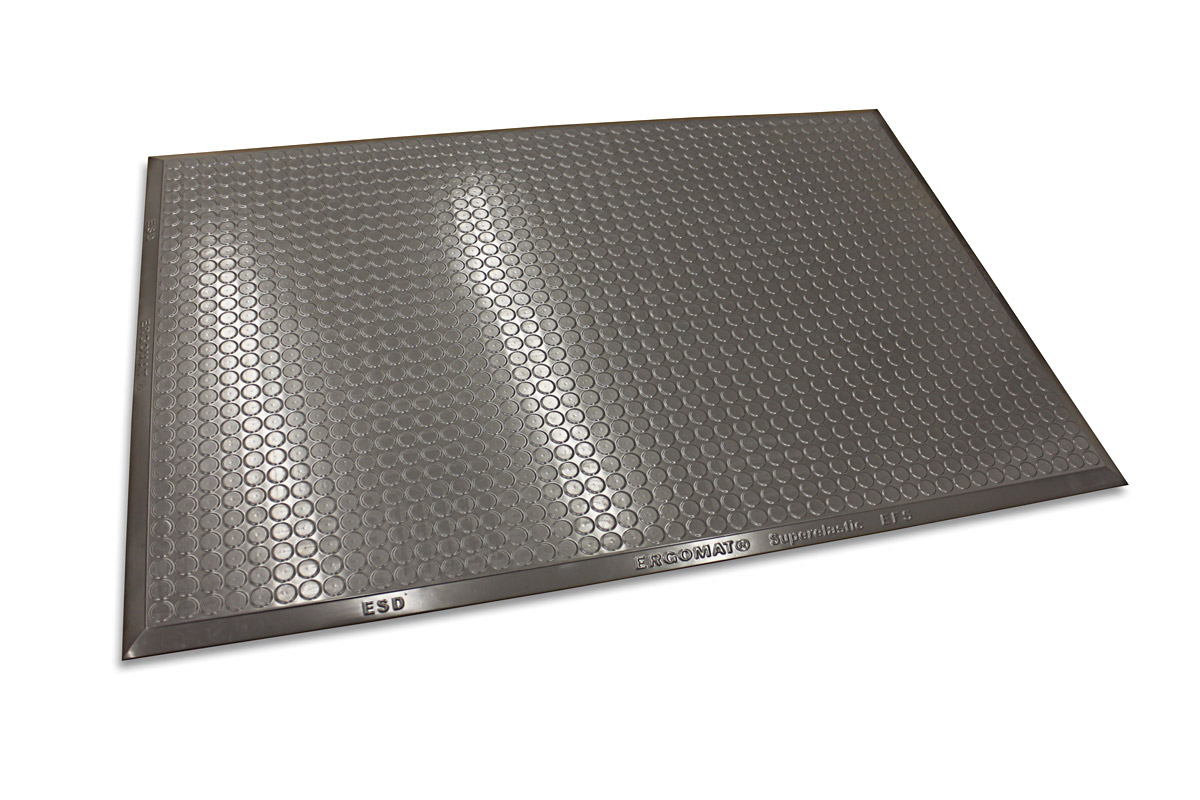 Grijze ergonomische stamat met fijn hexagonaal noppenpatroon en zilverkleurige rand, gefotografeerd van bovenaf / Tapis anti-fatigue ergonomique gris avec un fin motif de picots hexagonaux et un bord argenté, photographié de dessus