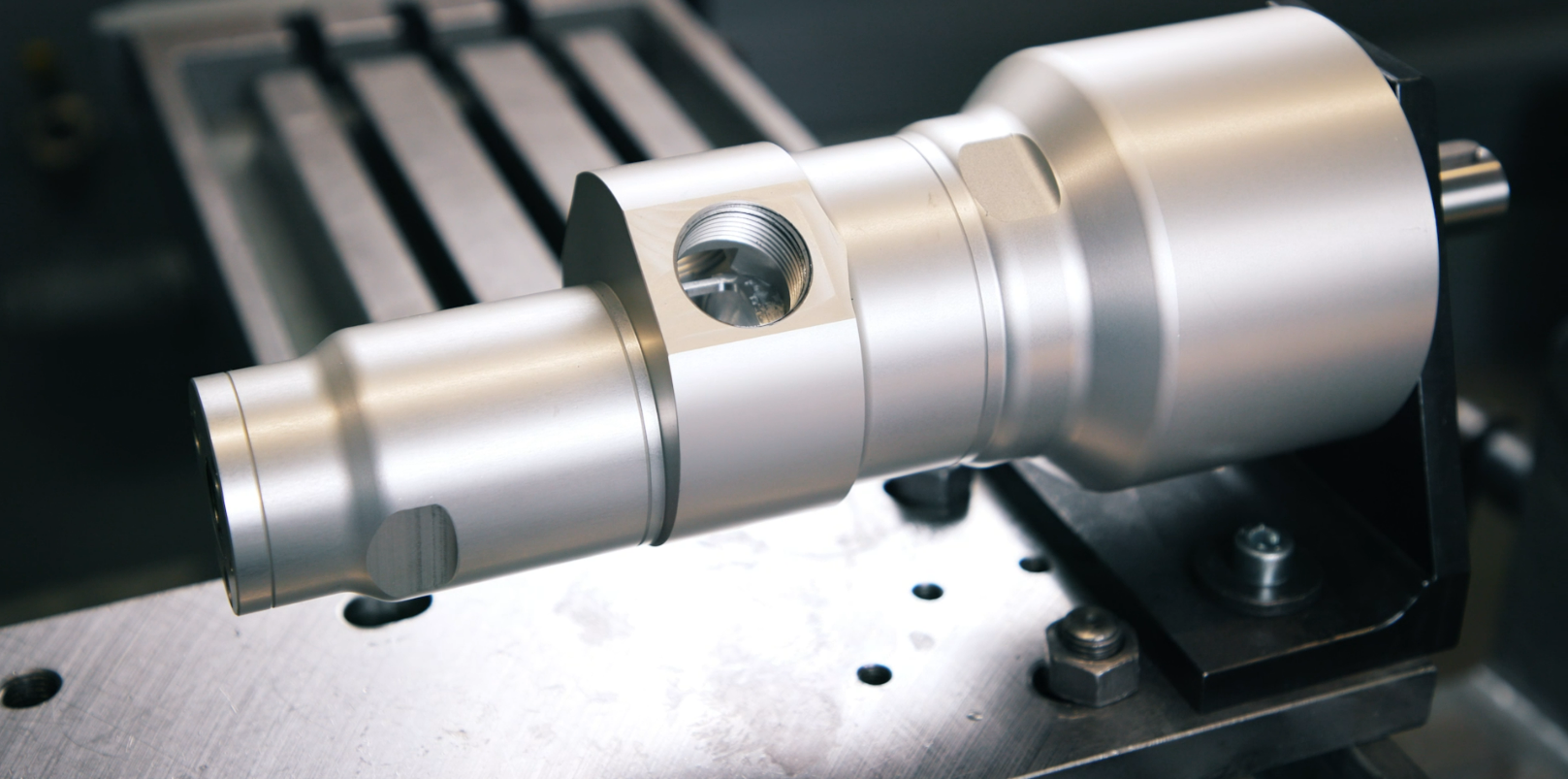 Close-up van een glanzende Deprag turbinemotor in aluminium, gemonteerd op een metalen houder in een CNC-machine.