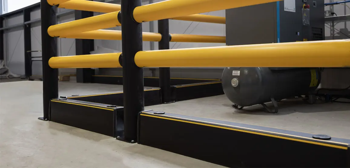 Gele Forkguard barrière met meerdere horizontale buizen en zwarte sokkel, geplaatst rond een compressorinstallatie in een industriële ruimte