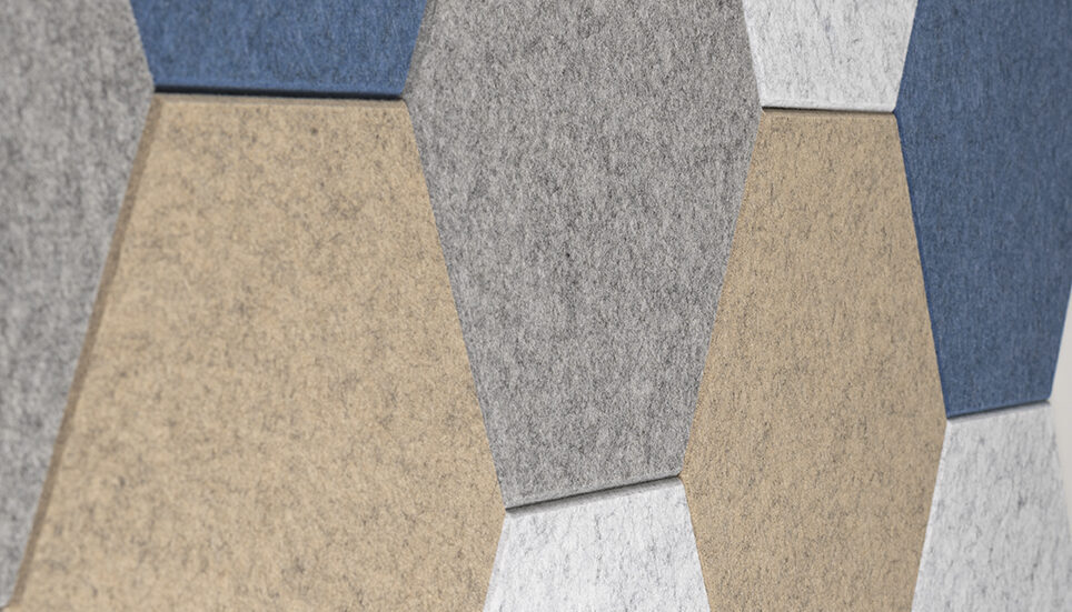 Close-up van akoestische hexagon tegels in beige, grijs en blauw als wandbekleding voor geluidsabsorptie