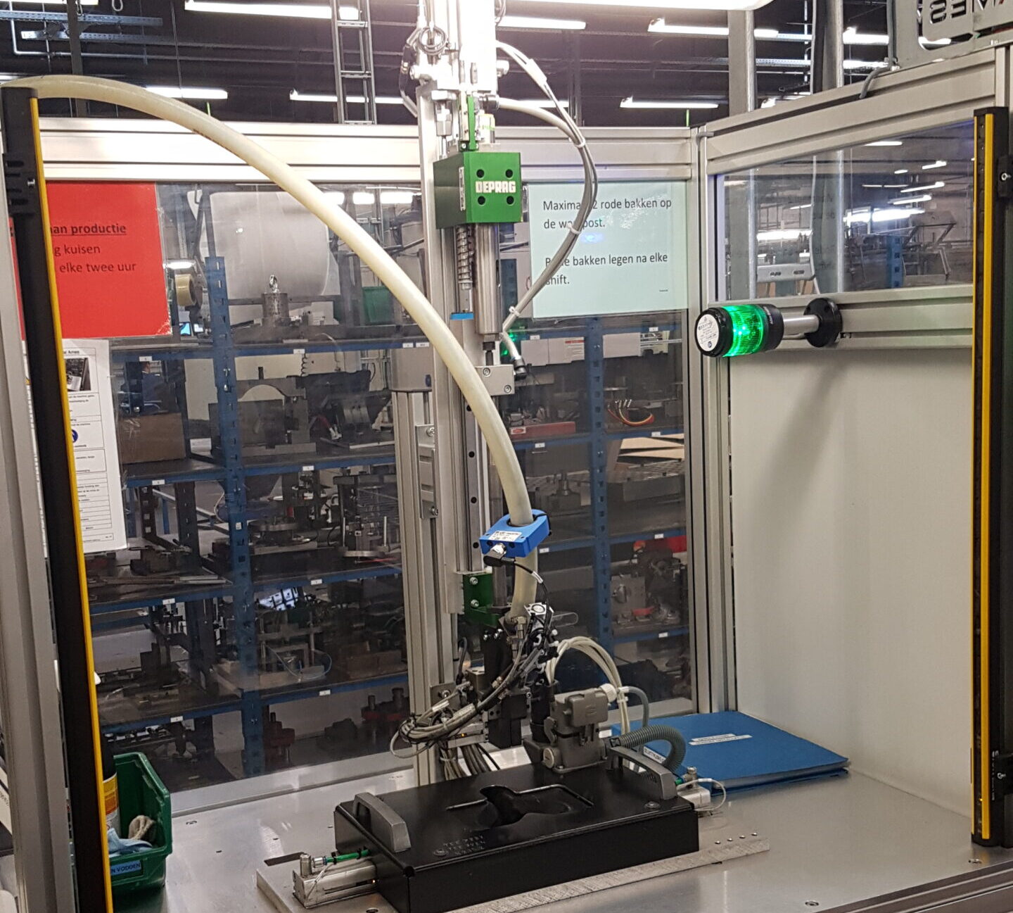 DEPRAG schroefmodule op lineaire as in een actieve schroefcel bij Pedeo, met schroeftoevoerslang, groene signaallamp en werkinstructies op de transparante wand