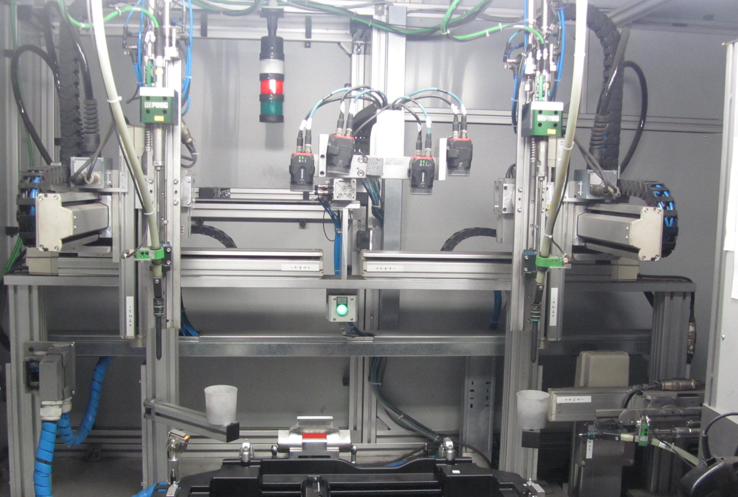 Binnenzijde van een geautomatiseerde schroefcel met twee DEPRAG schroefmodules, lineaire geleidingen, pneumatische actuatoren en een rood-groene signaallamp bovenaan