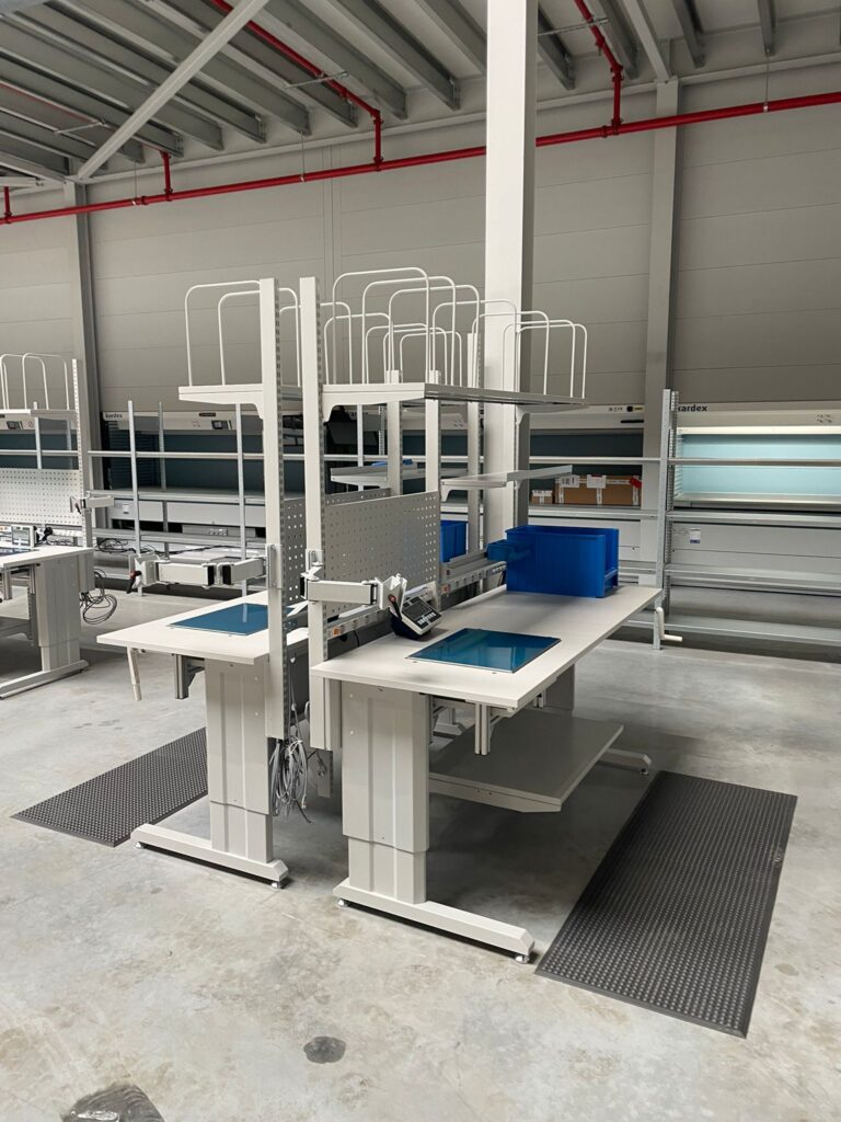 Elektrisch hoogteverstelbere werkposten met weegschalen en antivermoeidheidsmatten, onderdeel van de ergonomische werkpostinrichting voor Pro@Work