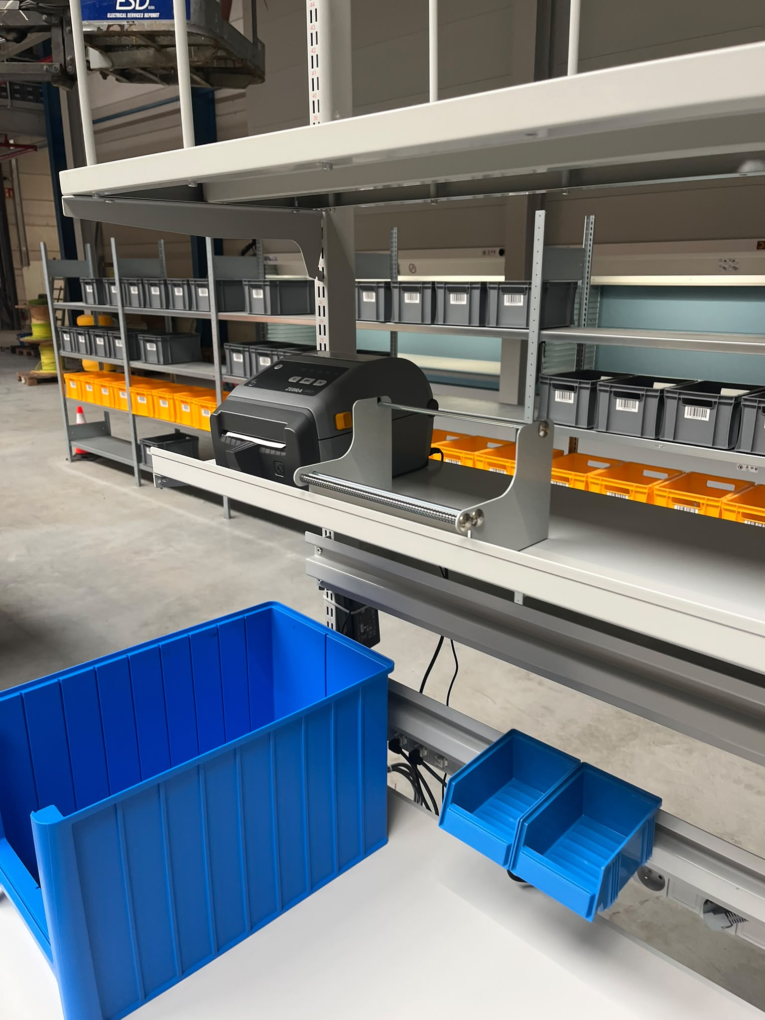 Geïntegreerd pickstation met labelprinter en magazijnbakken als onderdeel van de ergonomische werkposten in het magazijn van Pro@Work