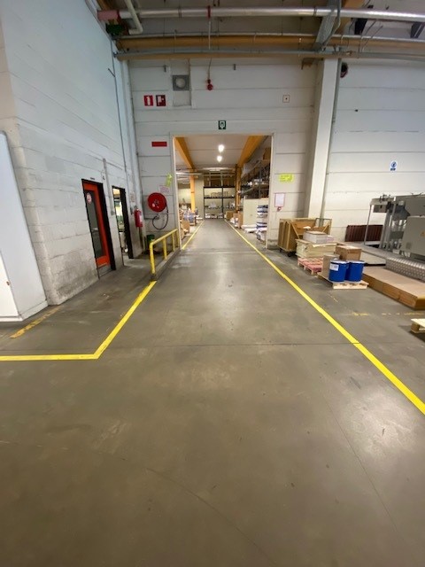 Gele belijning die de verkeersorganisatie structureert in de productieomgeving van Brepols